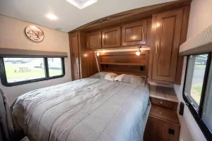 The bedroom features a queen-size bed, ample cabinetry, and plug-ins for electronic devices in each nightstand.