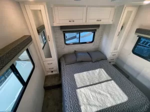 The rear queen bed is surrounded by windows for cross ventilation.