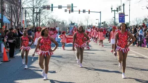 Cheerleaders participate in a family-friendly MLK Day Mardi Gras parade.