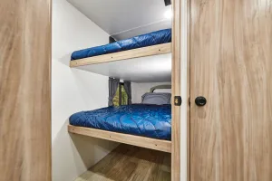 In the bunk room, the bottom bed flips up for access to the Pack-N-Play cubby.
