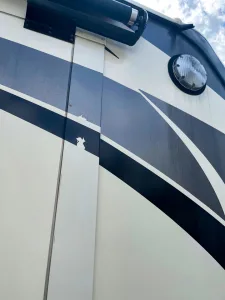 This slideout needs vinyl replacement after damage from a pressure washer and staining from a roof coating job.