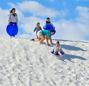 Sledding down the dunes is a popular park activity. The White Sands visitor center sells plastic saucers and wax.