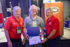 Gary Milner and Rett Porter present a certificate to Richard Taddeo for completing all FMCA University courses.