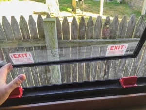 Emergency exit windows have red latches and must be marked with stickers.