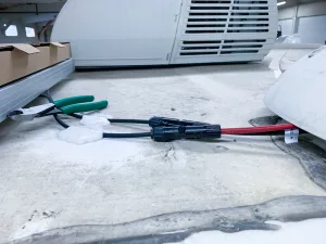 Back on the roof, apply sealant to secure the wires between the solar panel and the fridge vent.