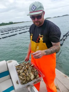 Cody Faison from the Ghost Fleet Oyster Co. welcomes visitors at his working oyster farm.