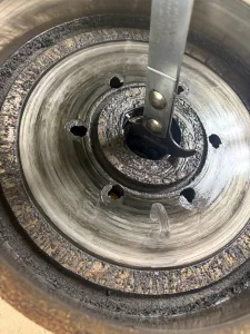 After the brake drums have been removed and the outer bearings, nuts, and washers have been sorted, use a seal puller to remove the wheel seals from the drum. 
